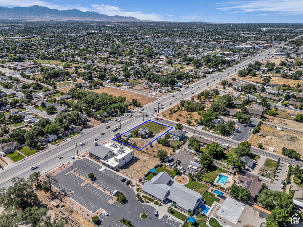 Aerial view of property and surrounding area featuring a mountainous background and property boundaries highlighted