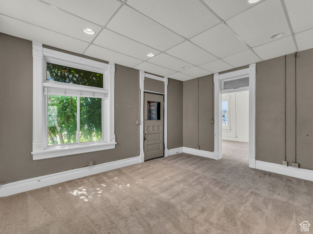 Carpeted empty room with a drop ceiling and recessed lighting