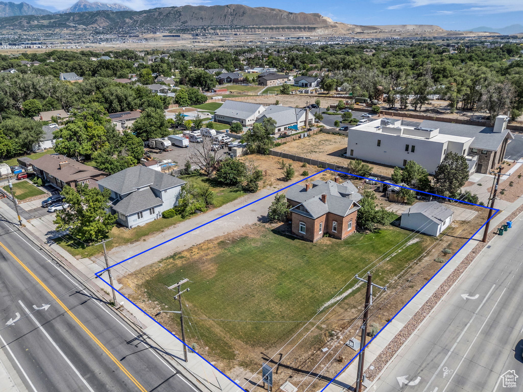 Aerial view of residential area with property parcel outlined and a mountain backdrop