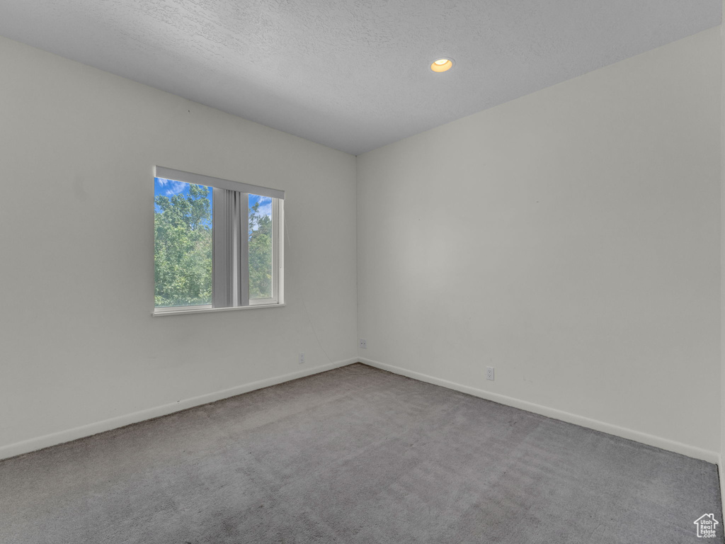 Carpeted spare room featuring recessed lighting and a textured ceiling