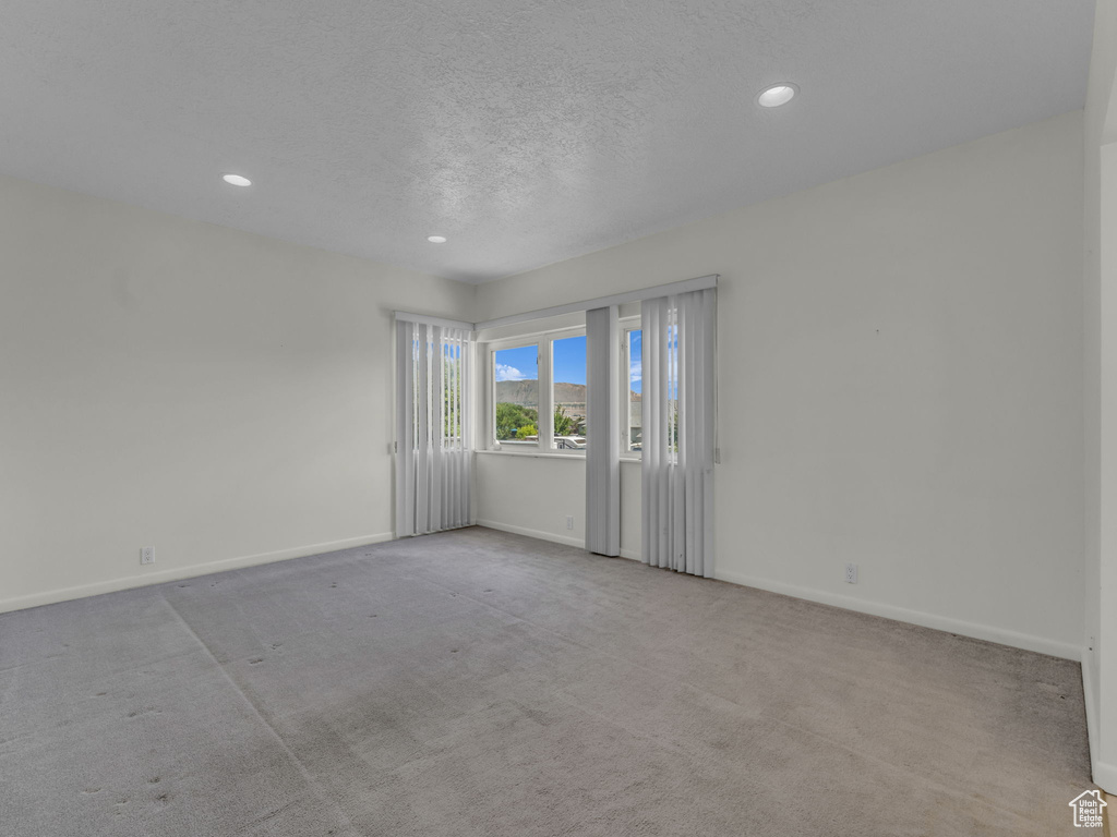 Empty room with recessed lighting, carpet floors, and a textured ceiling
