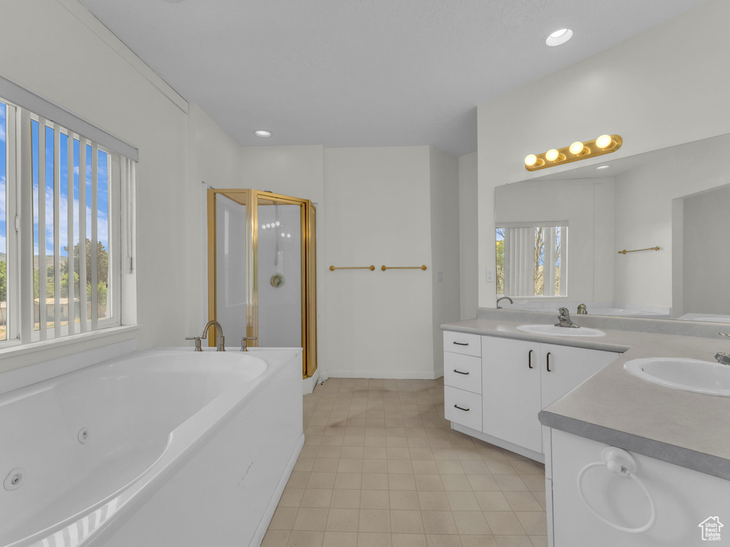 Bathroom featuring a stall shower, double vanity, a whirlpool tub, recessed lighting, and tile patterned flooring