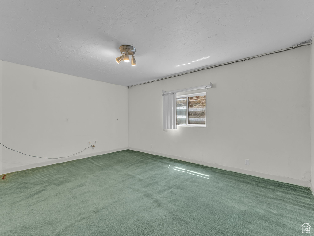 Carpeted empty room featuring baseboards