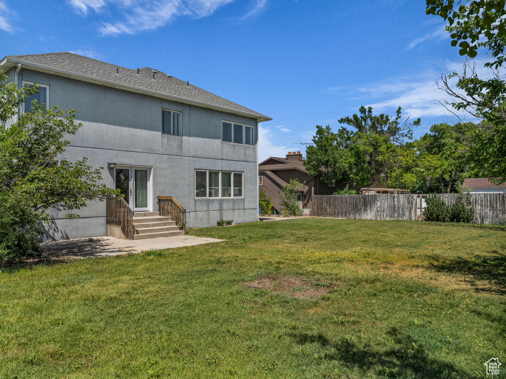 Rear view of house with stucco siding and a patio area