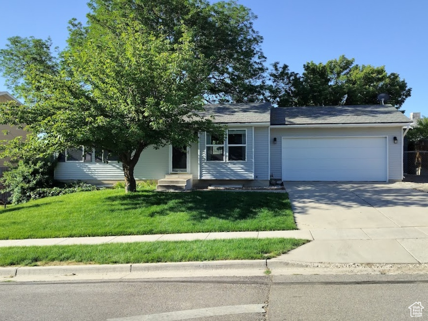 View of front of property with an attached garage, concrete driveway, and entry steps