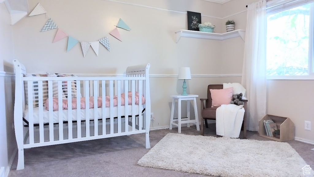 Carpeted bedroom with multiple windows and a nursery area