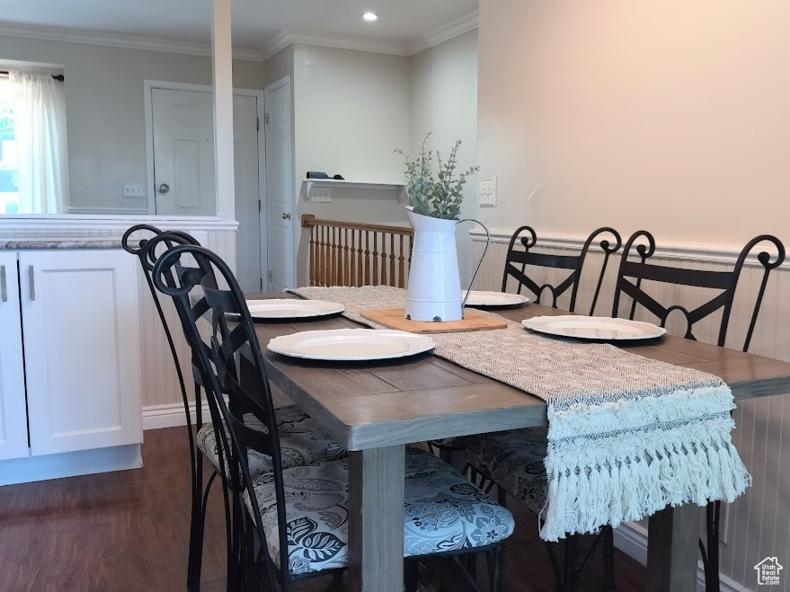 Dining room featuring dark wood-type flooring, ornamental molding, and recessed lighting