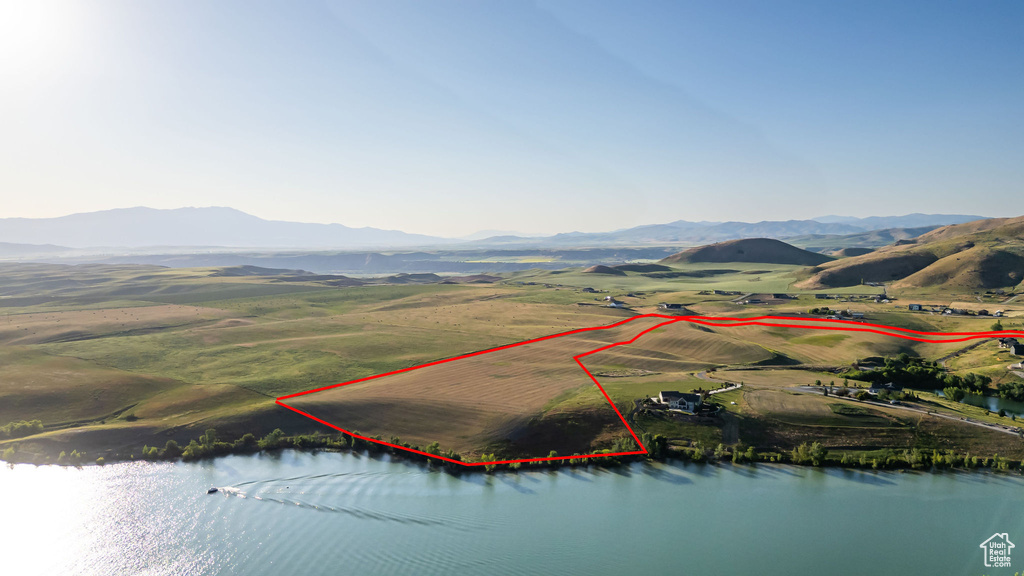 Aerial view of property and surrounding area with property parcel outlined and a water and mountain view