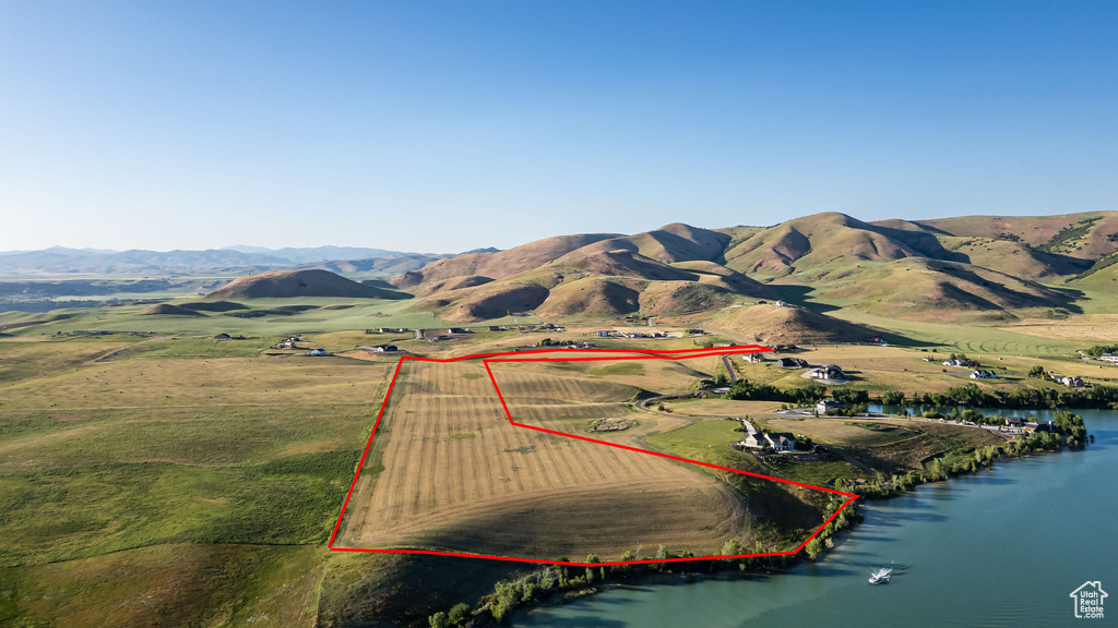 Aerial view of sparsely populated area with property parcel outlined and a water and mountain view
