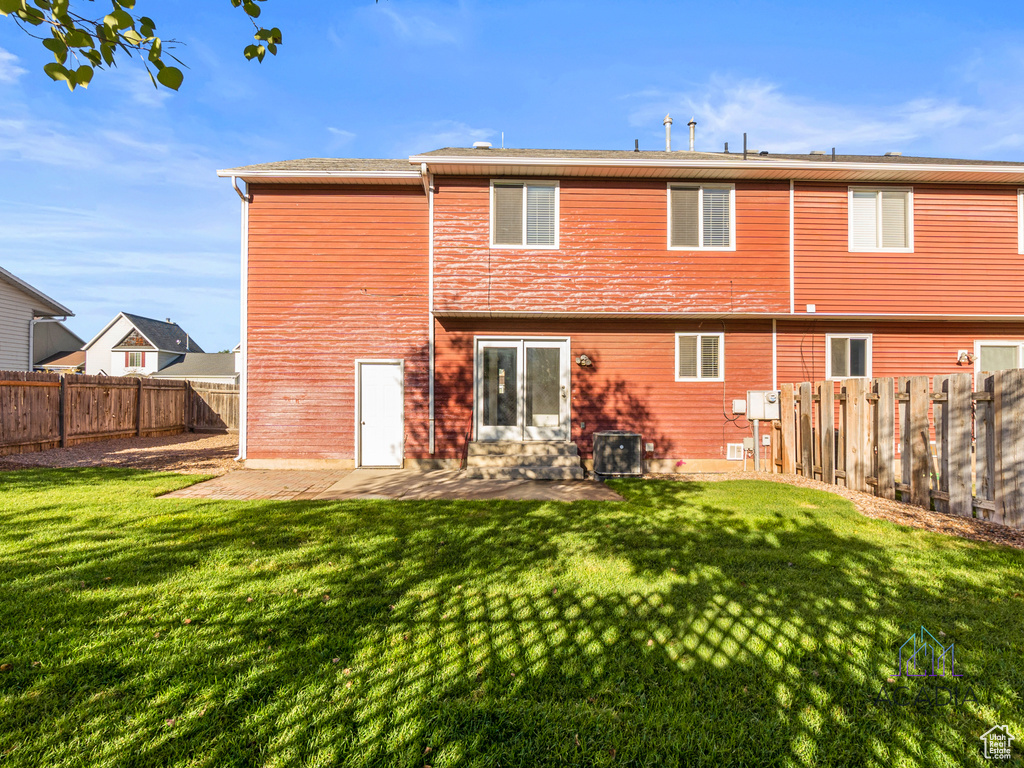 Back of house with a fenced backyard and a patio