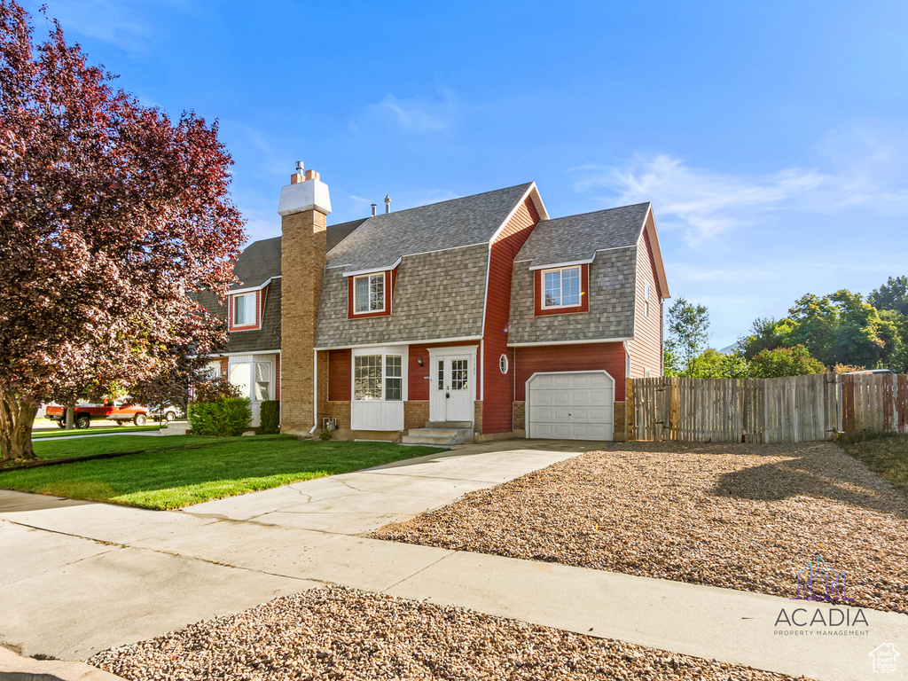 Colonial inspired home featuring roof with shingles, a gambrel roof, a chimney, concrete driveway, and a garage