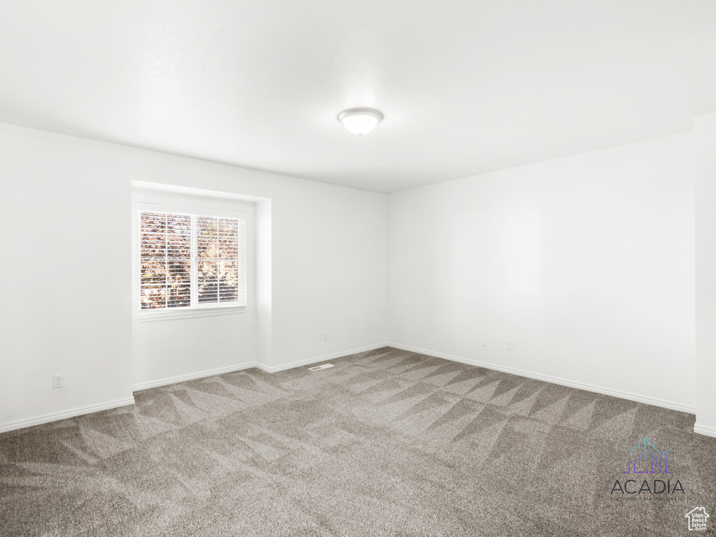 Empty room featuring carpet floors and baseboards