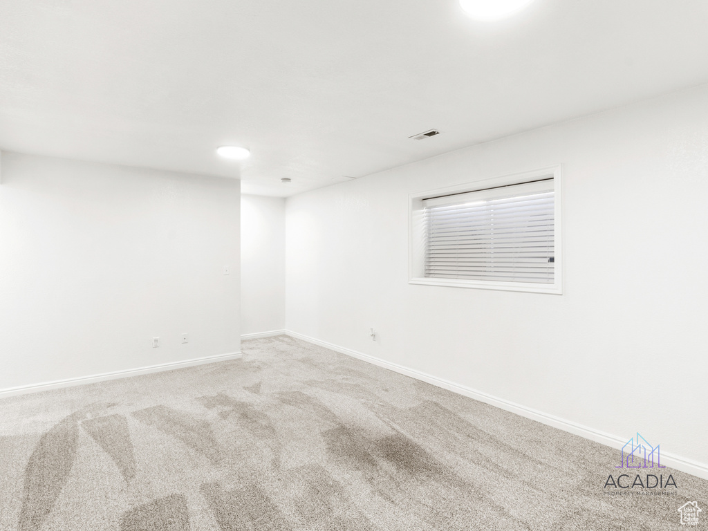 Carpeted empty room with baseboards