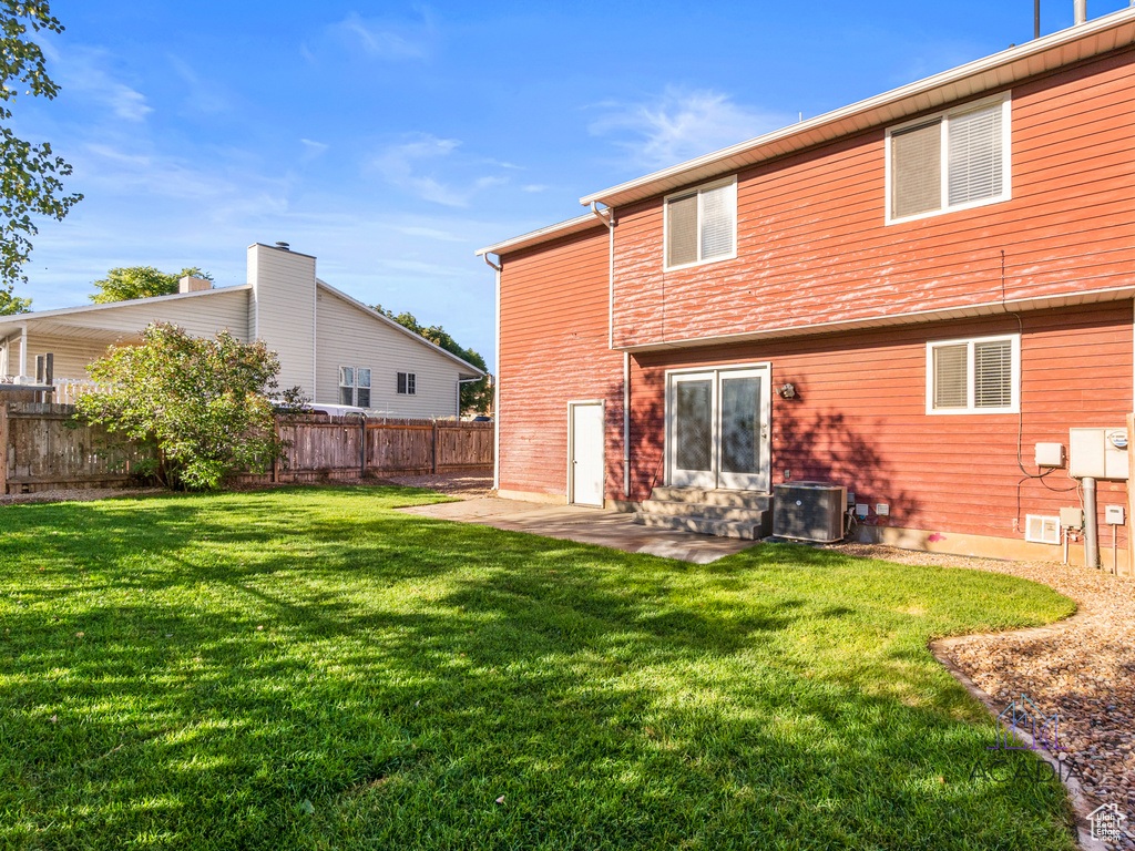 Rear view of house with a fenced backyard and a patio area