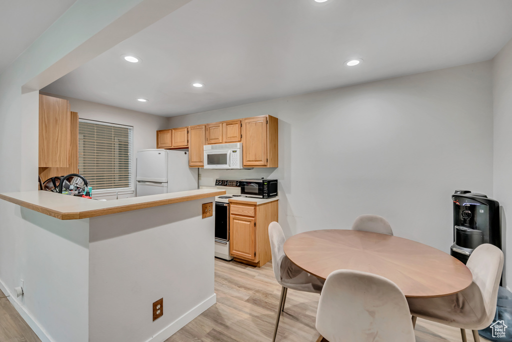 Kitchen featuring white appliances, light wood-style floors, recessed lighting, light brown cabinetry, and light countertops