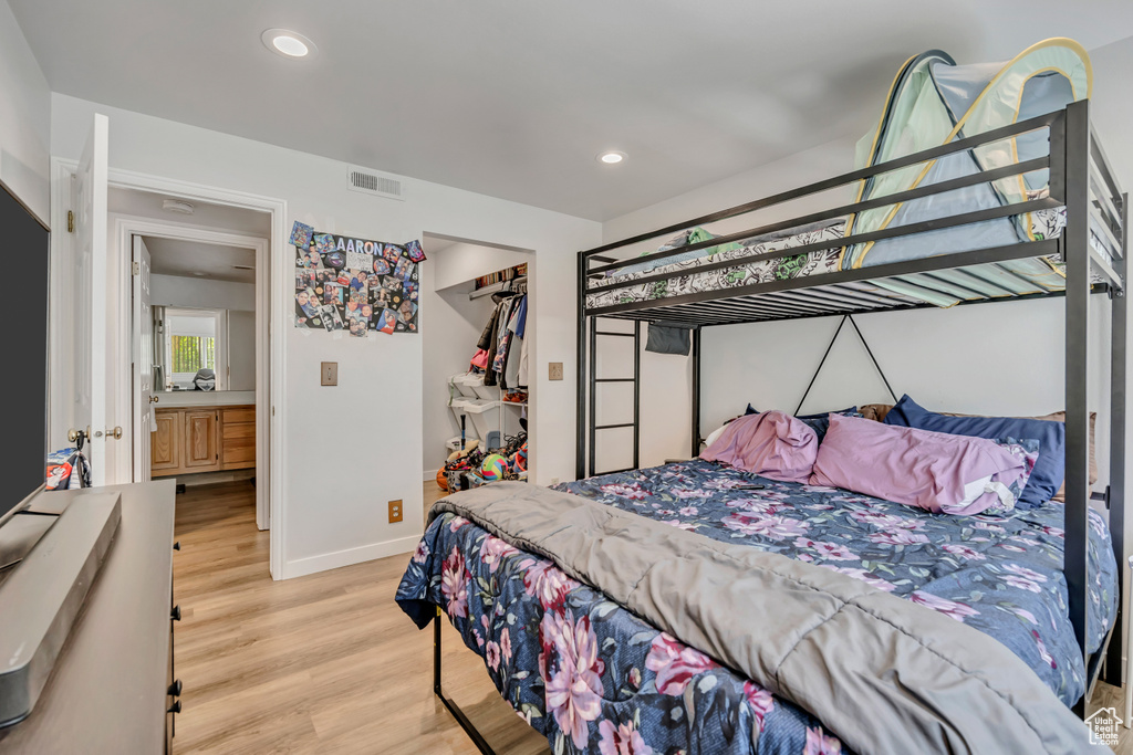Bedroom featuring light wood-style flooring, recessed lighting, a closet, and a walk in closet