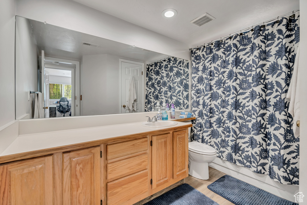 Full bathroom with vanity, wood finished floors, and recessed lighting