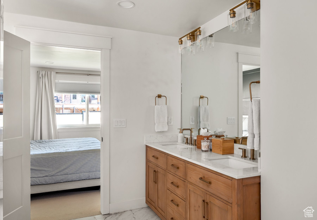 Ensuite bathroom featuring marble look tile flooring and double vanity