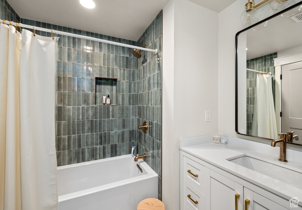 Bathroom featuring shower / tub combo, vanity, and recessed lighting