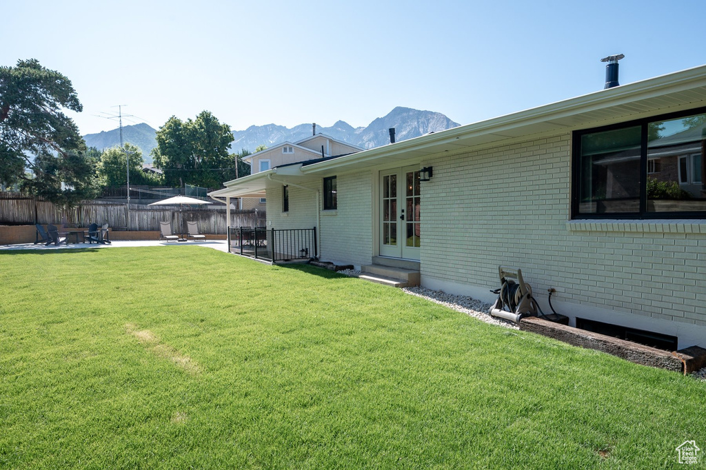 Fenced yard featuring french doors, a patio area, a mountain view, and entry steps