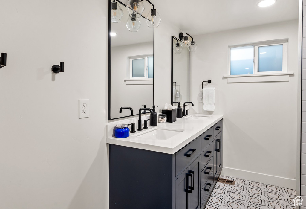 Bathroom with double vanity and baseboards