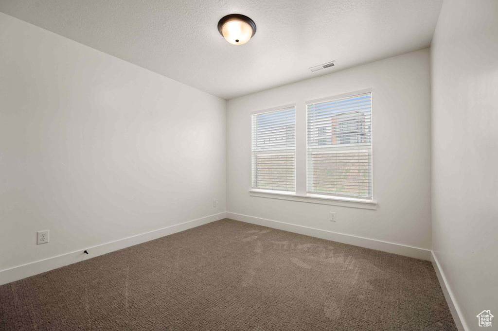 Carpeted empty room with baseboards