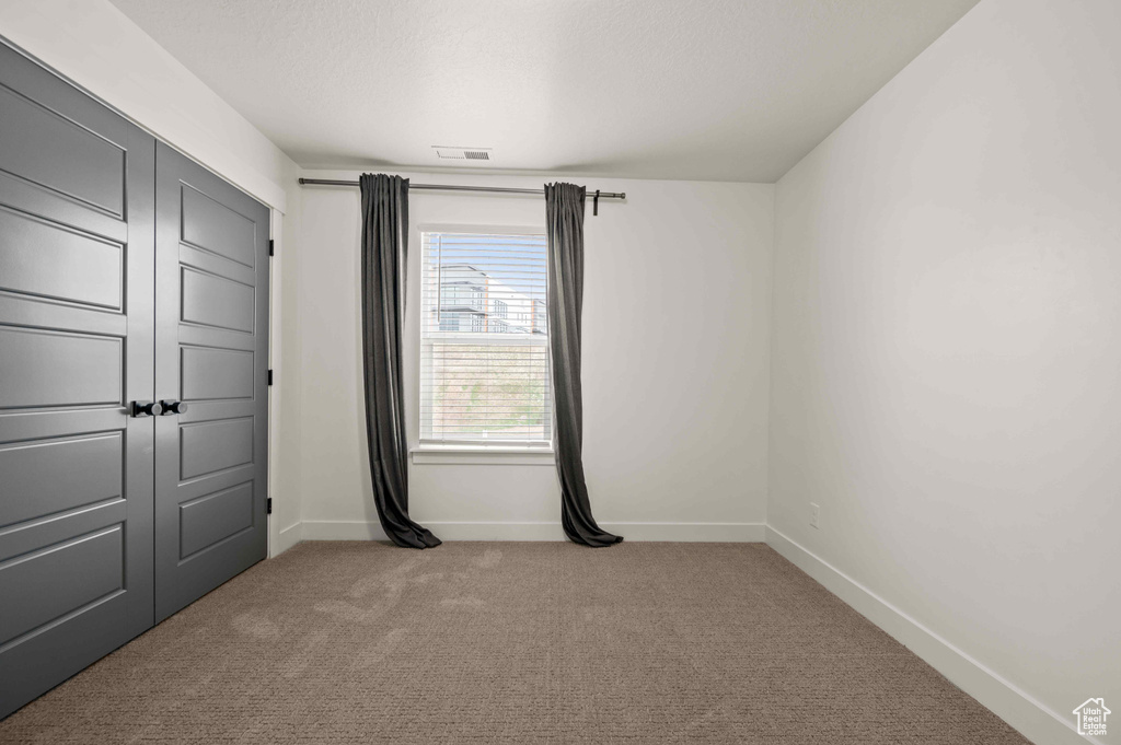 Unfurnished bedroom with carpet floors and baseboards