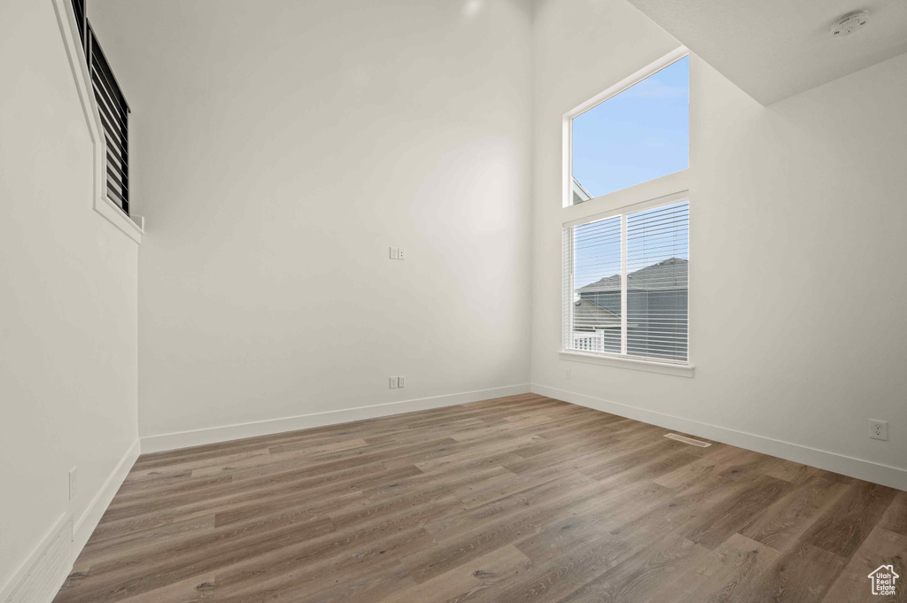 Empty room with a smoke detector and wood finished floors