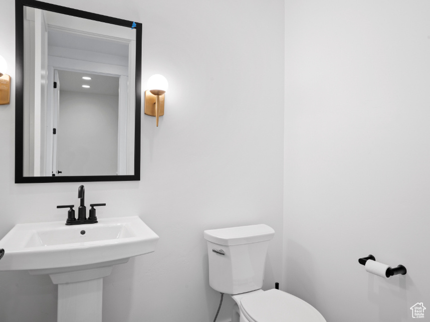 Half bathroom with toilet and a sink