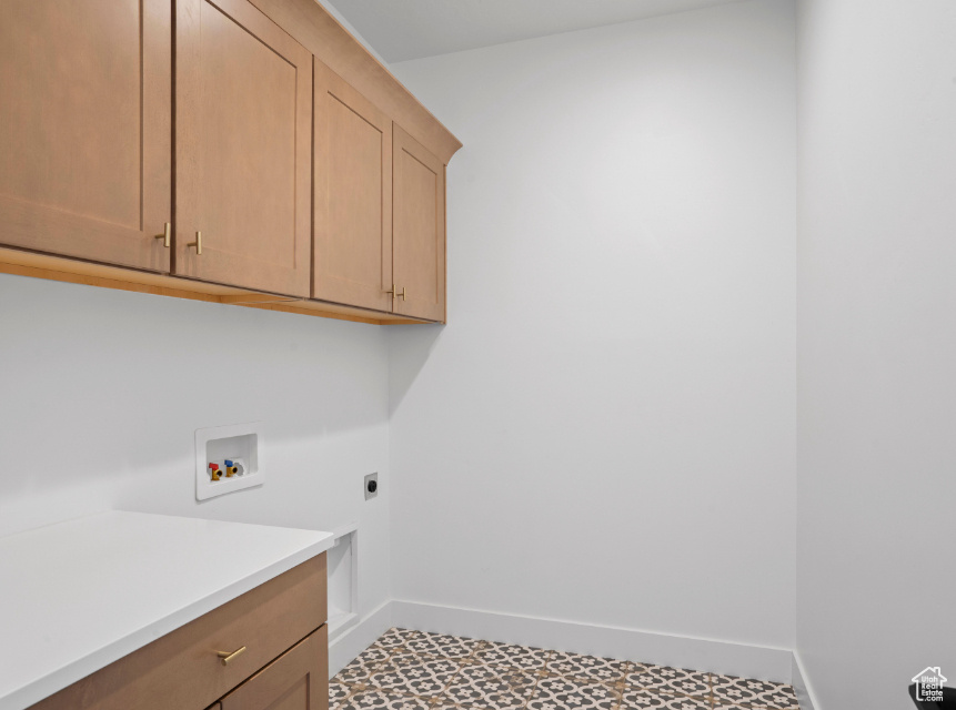 Laundry area with cabinet space, hookup for a washing machine, and hookup for an electric dryer