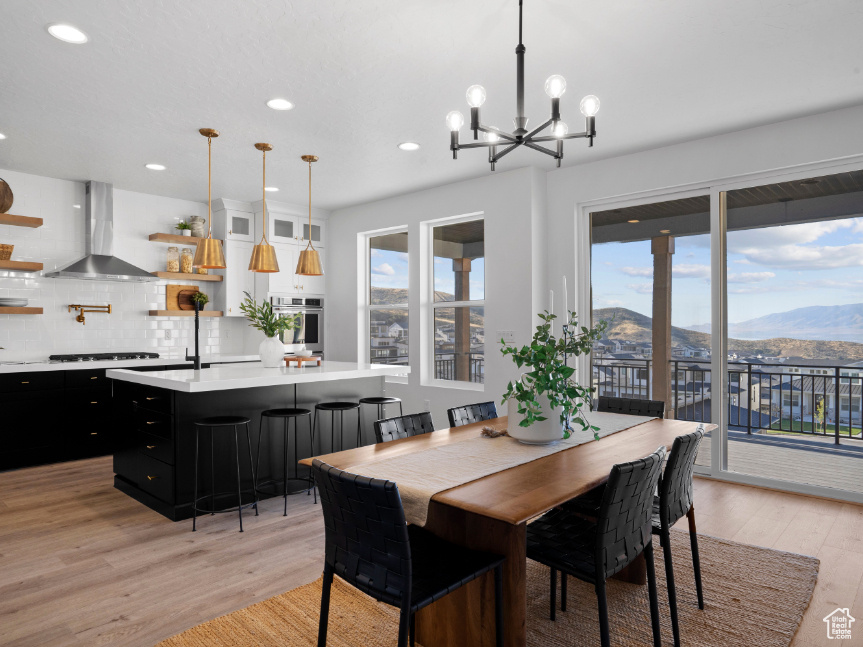 Dining room featuring a mountain view, light wood finished floors, a chandelier, and recessed lighting