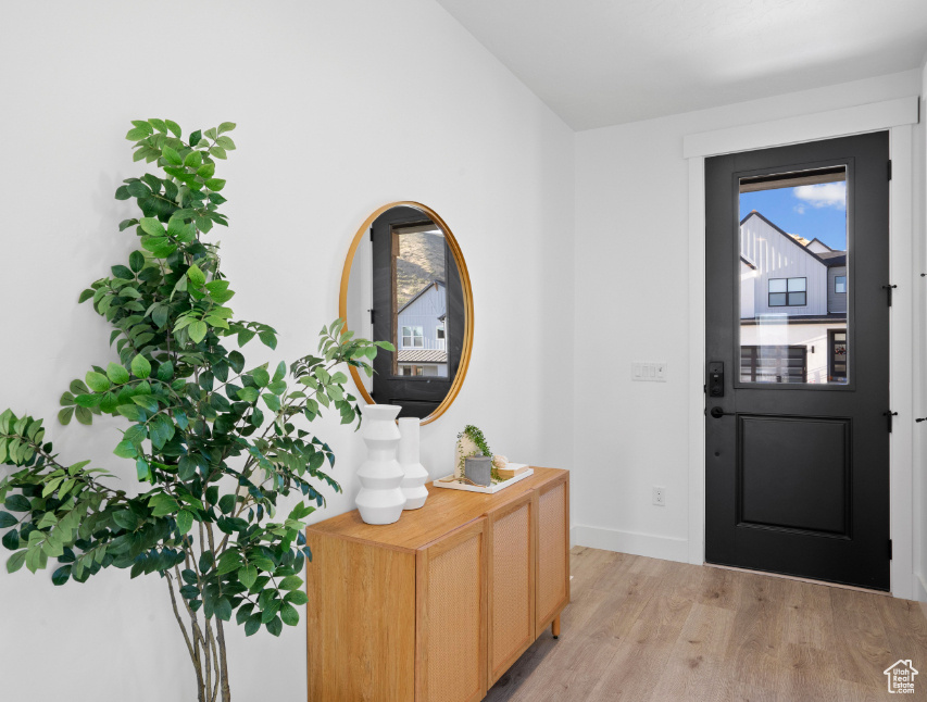 Entrance foyer featuring light wood-style flooring and vaulted ceiling