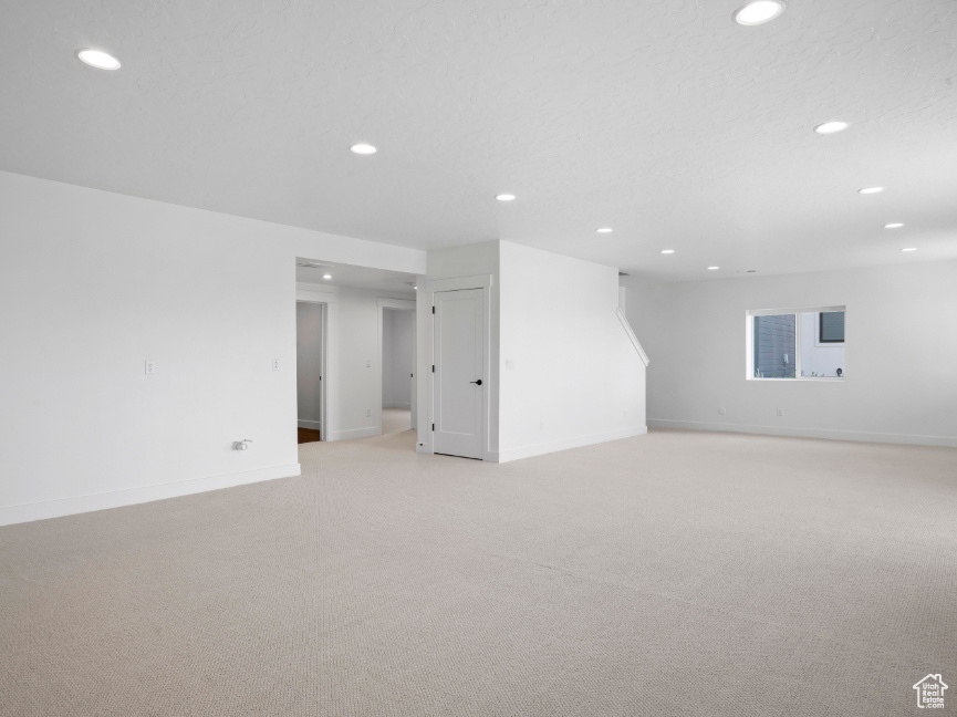 Basement with recessed lighting and light colored carpet