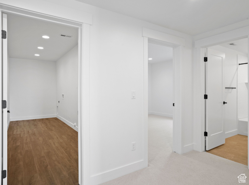 Hallway with wood finished floors and recessed lighting