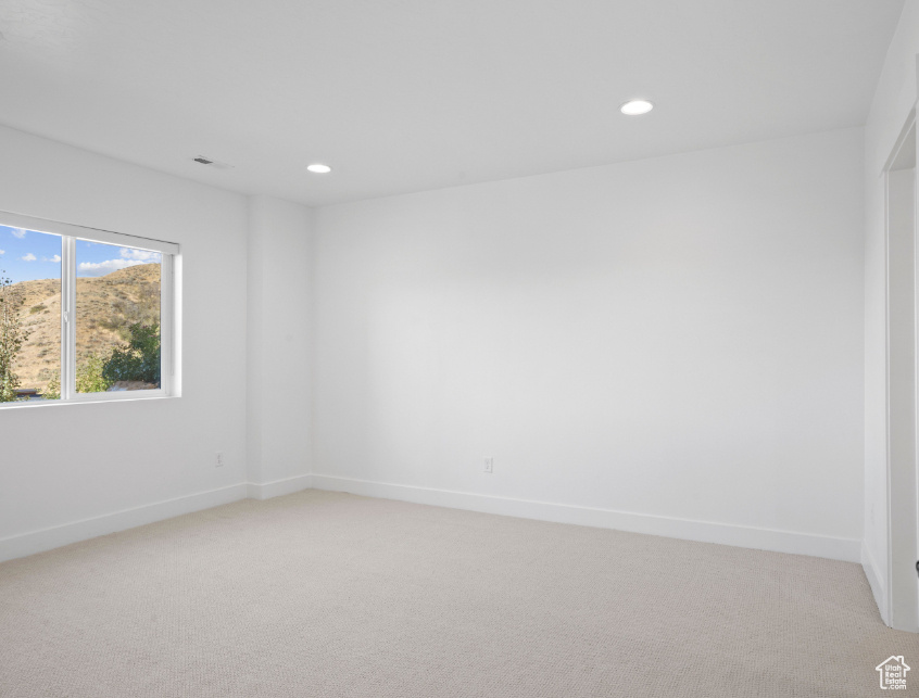 Unfurnished room featuring light carpet and recessed lighting