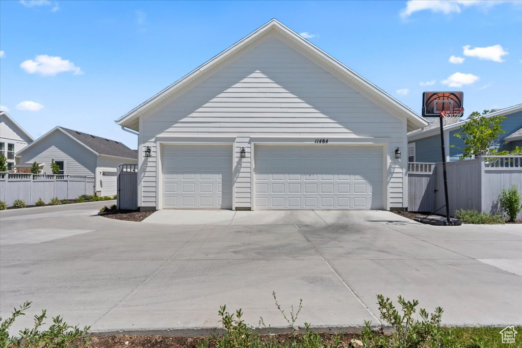 View of property exterior with an outdoor structure and a detached garage
