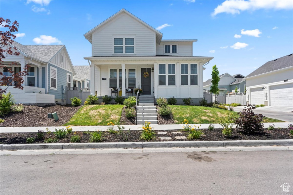 Traditional home featuring a porch, stairs, and an attached garage