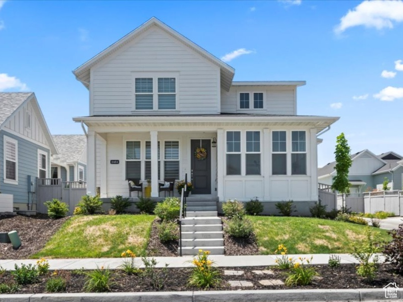 Traditional home featuring a porch, stairs, and an attached garage