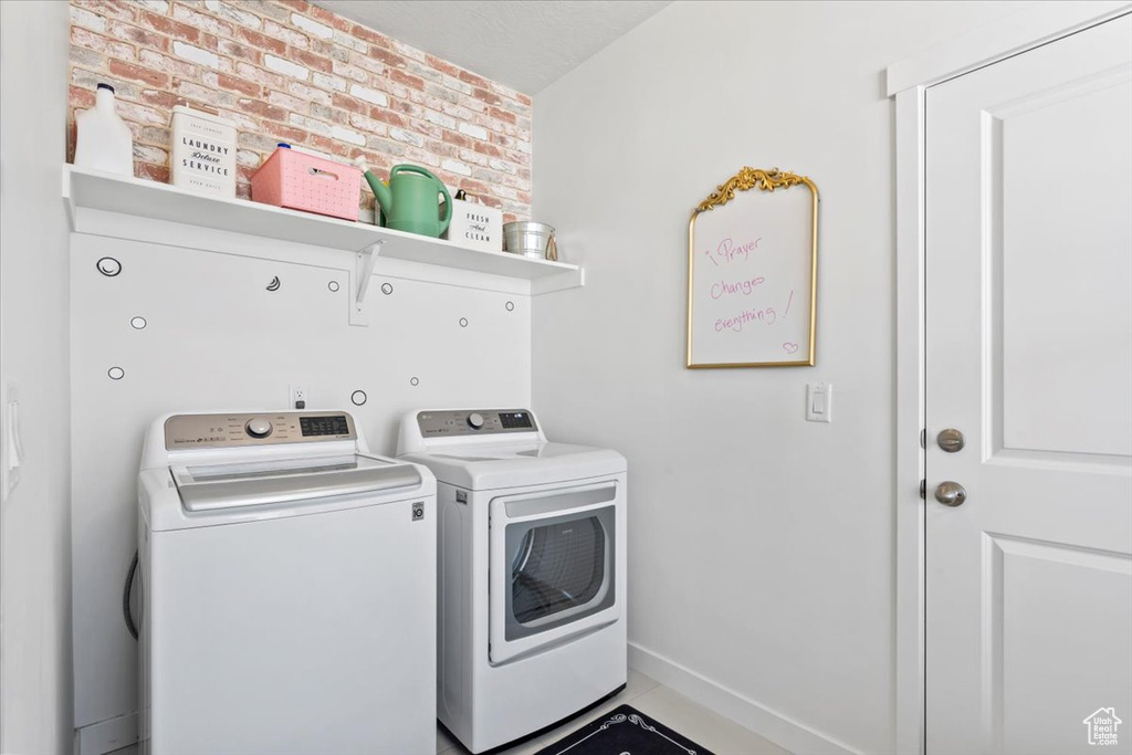 Laundry area with washer and clothes dryer and baseboards