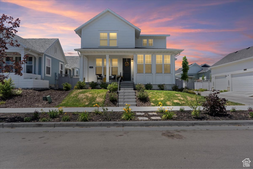 Traditional-style house featuring board and batten siding, a porch, stairs, and a front lawn