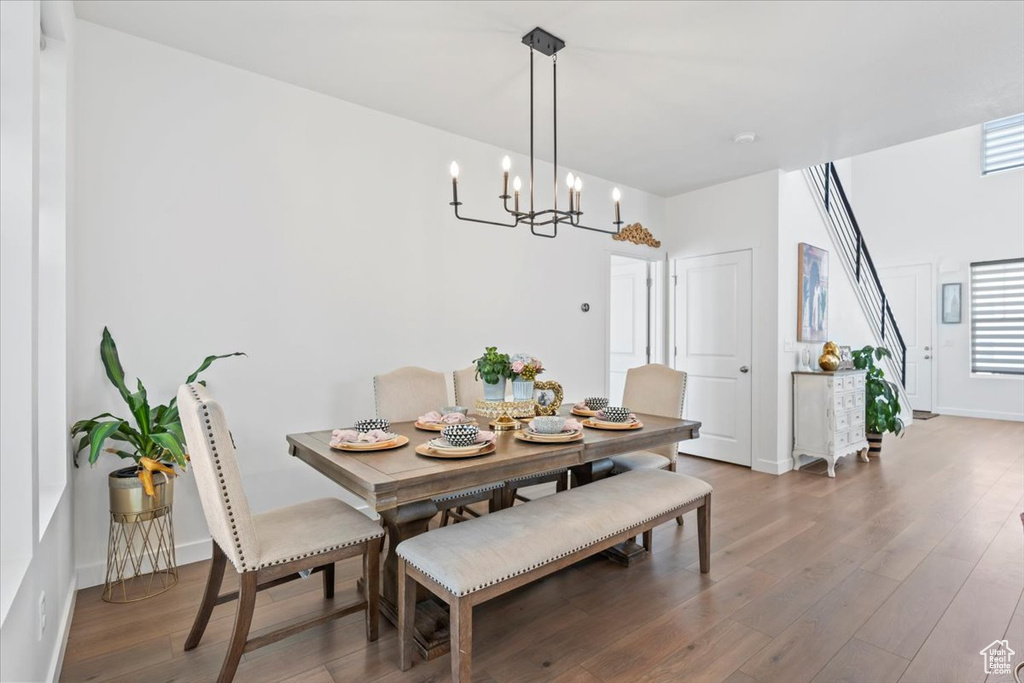 Dining space with wood finished floors and a chandelier