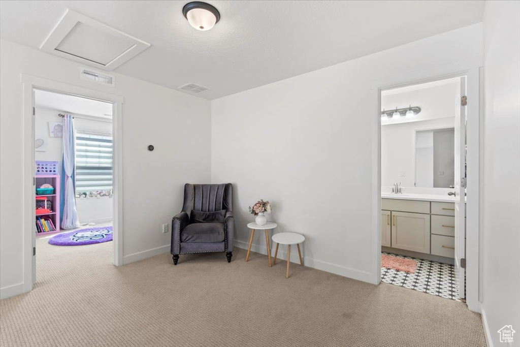 Living area with light carpet and attic access