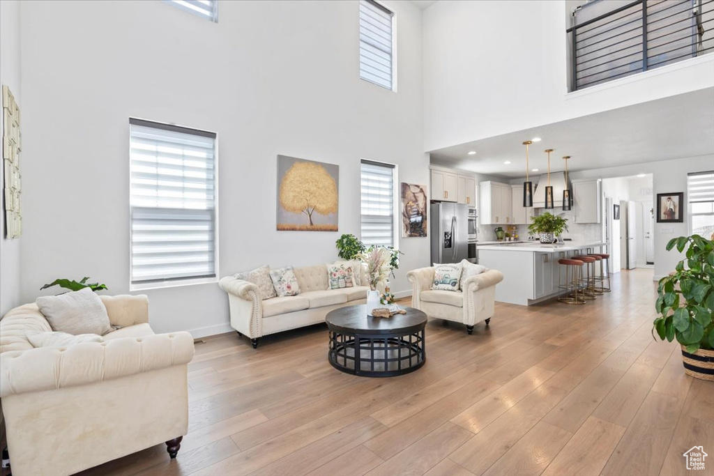 Living room featuring a towering ceiling and light wood-type flooring