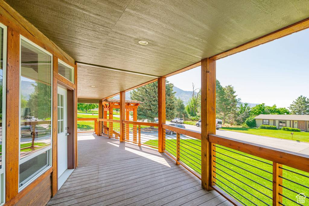 Deck with a mountain view and a lawn