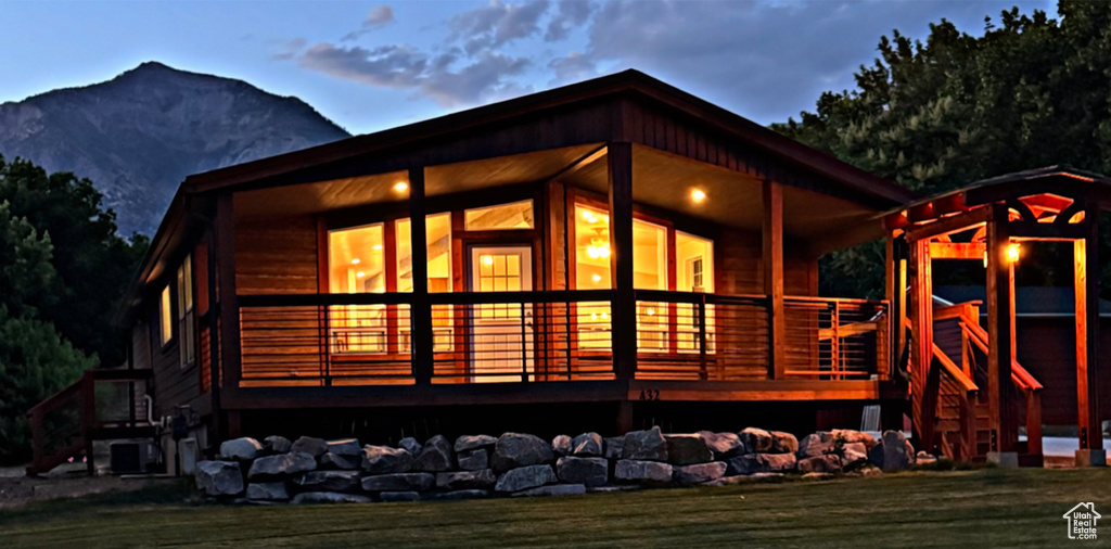 Back of house featuring a mountain view and a lawn