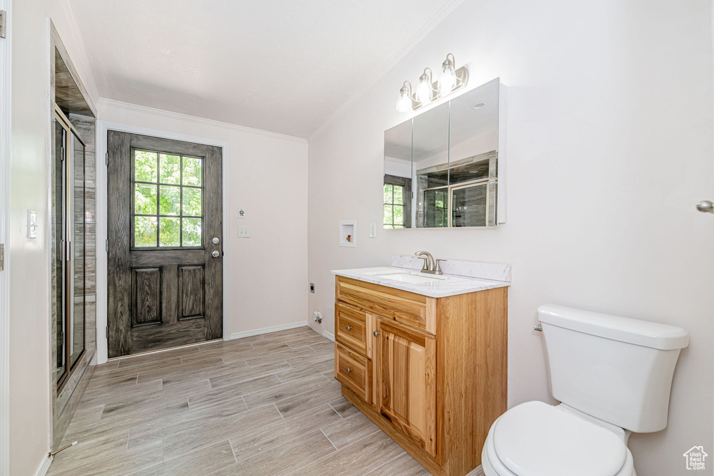 Full bathroom with vanity, ornamental molding, wood tiled floors, and a shower stall