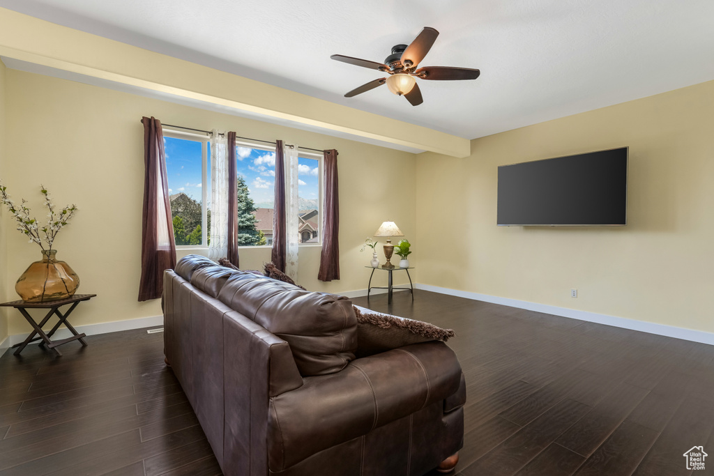Living room with dark wood-type flooring and ceiling fan