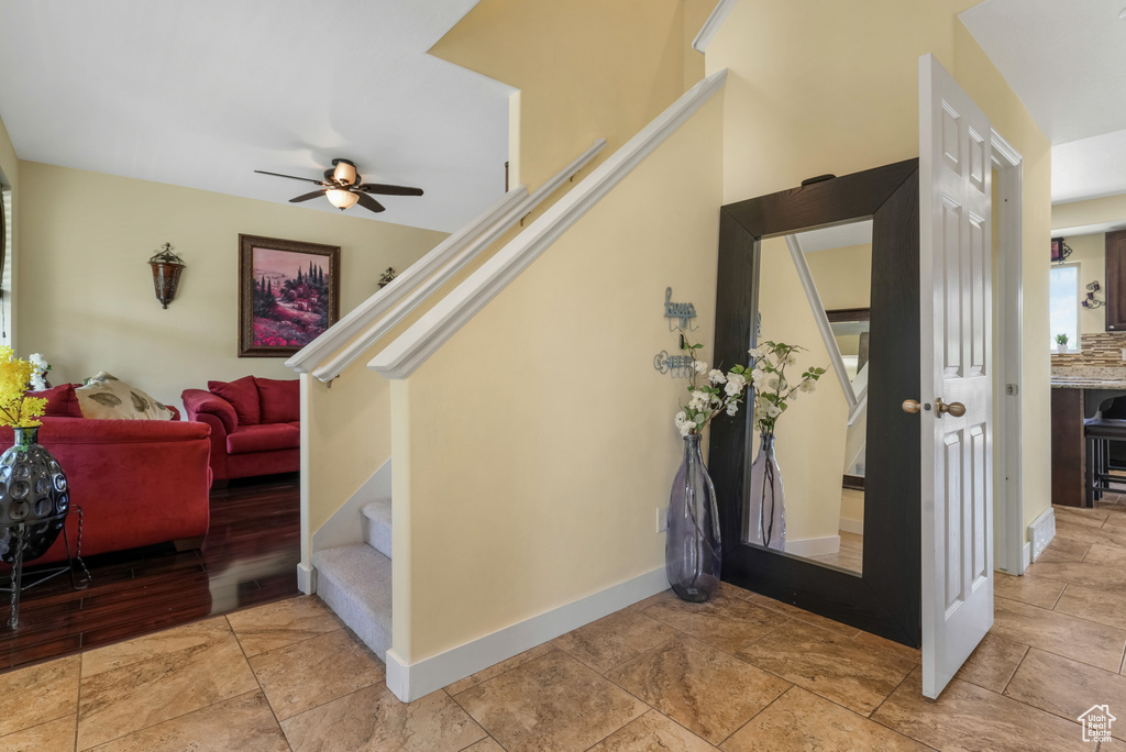 Foyer entrance with stairway and a ceiling fan