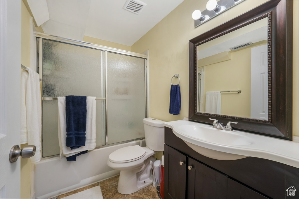 Full bathroom with vanity and enclosed tub / shower combo