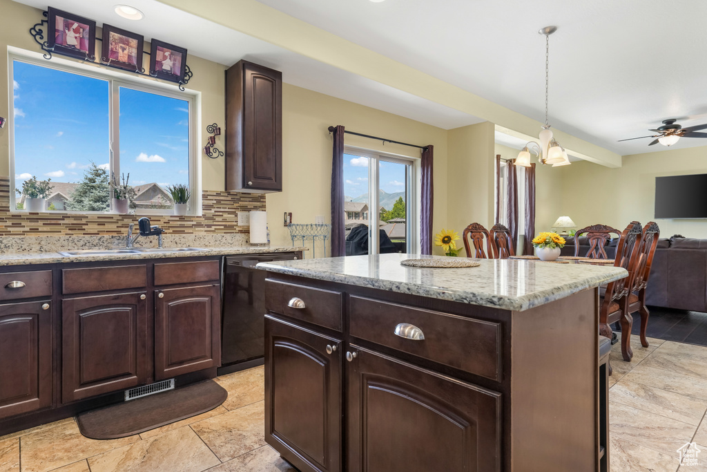 Kitchen with dishwasher, backsplash, a center island, and dark brown cabinetry